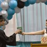 Guest speaker Donica Nash gave out candy matching each student, including this package of JOYRIDE to Gideon Pankratz, at the River City Academy graduation ceremony Tuesday, May 20, 2025, at Skyview Middle School just outside of Soldotna, Alaska. (Photo by Jeff Helminiak/Peninsula Clarion)