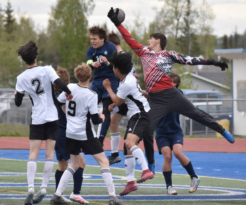 Soldotna defender Daniel Heath and goalie Luke Hillyer sky through the air to keep the ball out of the net Thursday, May 22, 2025, at Justin Maile Field at Soldotna High School in Soldotna, Alaska. (Photo by Jeff Helminiak/Peninsula Clarion)