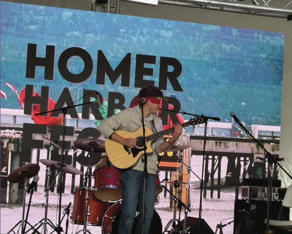 Local musician Silas Luke Jones performs blindfolded during his performance at the inaugural HomerFest on the Homer Spit on Saturday. (Chloe Pleznac/Homer News)