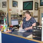 Anchor Point Library director Deanna Thomas works the library front counter on Friday, June 6, 2025, in Anchor Point, Alaska. (Delcenia Cosman/Homer News)