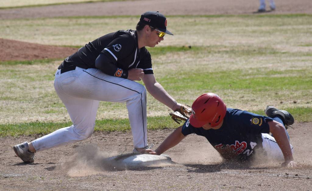 Post 20s Jackson Koetitz slides back safely to first in front of Wests Chase Thompson on Friday, June 13, 2025, at Coral Seymour Memorial Park in Kenai, Alaska. (Photo by Jeff Helminiak/Peninsula Clarion)