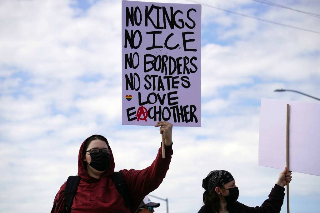 People carrying flags and signs line the Sterling Highway for a No Kings protest in Soldotna, Alaska, on Saturday, June 14, 2025. (Jake Dye/Peninsula Clarion)