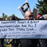 A demonstrator holds up a sign during the No Kings protest on Saturday, June 14, 2025, at WKFL Park in Homer, Alaska. (Chloe Pleznac/Homer News)