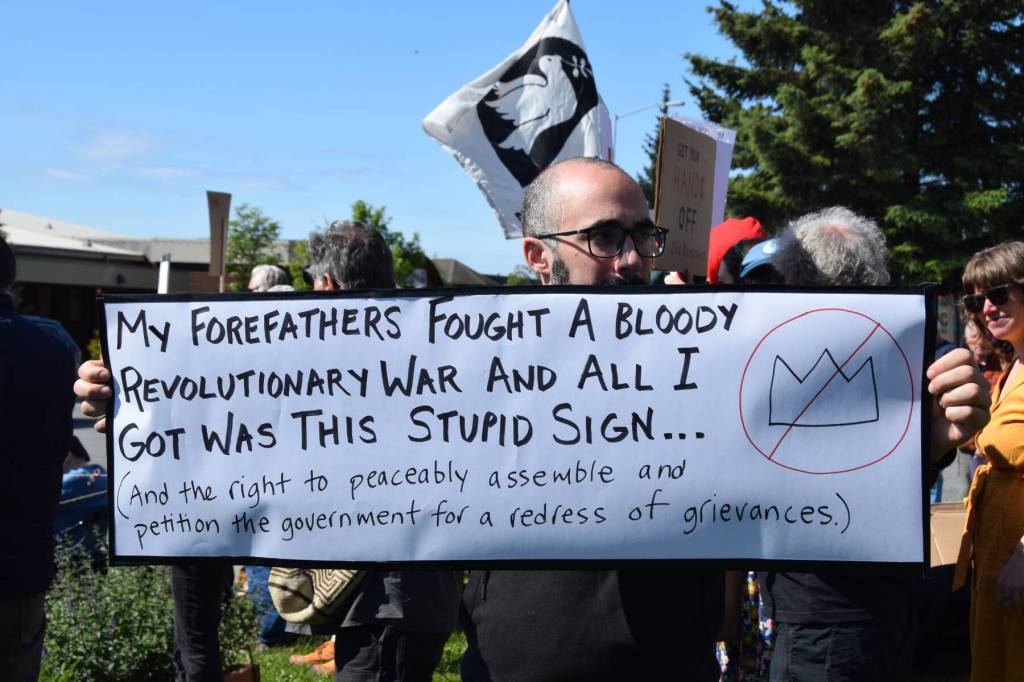 A demonstrator holds up a sign during the No Kings protest on Saturday, June 14, 2025, at WKFL Park in Homer, Alaska. (Chloe Pleznac/Homer News)