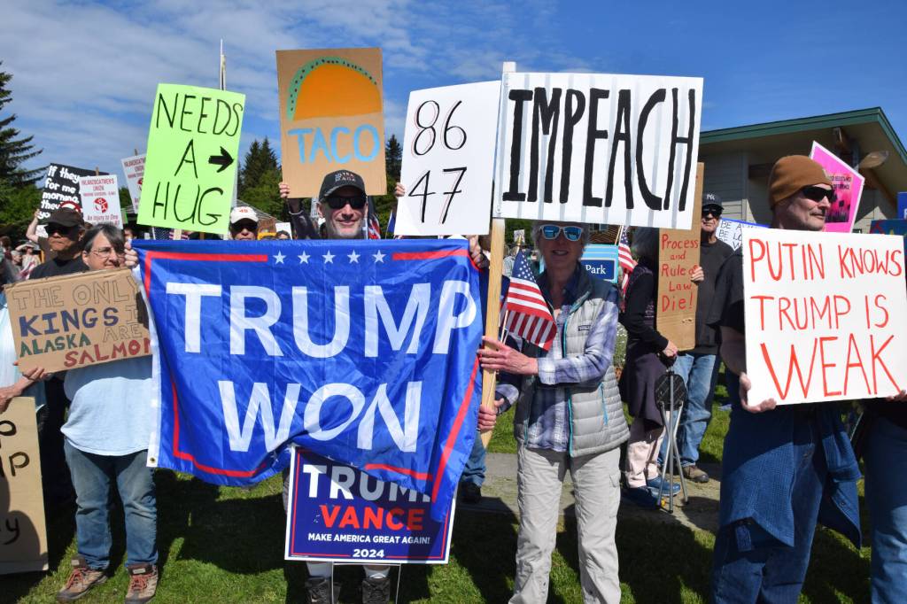 Demonstrators hold up signs on a crowded street corner during the No Kings protest on Saturday, June 14, 2025, at WKFL Park in Homer, Alaska. (Chloe Pleznac/Homer News)