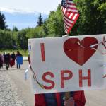 A woman stands with her sign held up during a rally in support of Medicaid and South Peninsula Hospital on Wednesday, June 18, 2025 in Homer, Alaska. (Chloe Pleznac/Homer News)