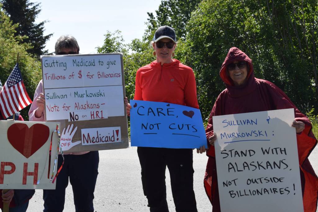 Marchers stand with signs during a rally in support of Medicaid and South Peninsula Hospital on Wednesday, June 18. (Chloe Pleznac/Homer News)
