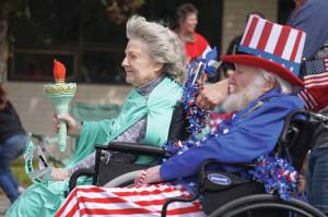 Aspen Creek Senior Living residents, dressed as the Statue of Liberty and Uncle Sam, roll down the Kenai Spur Highway in Kenai, Alaska, during the Fourth of July Parade on Thursday, July 4, 2024. (Jake Dye/Peninsula Clarion)