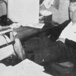 File photo from the Anchorage Times
Slim Eagleston, a junkyard owner who assaulted Frank Rowley and fractured his skull in 1946, is seen here with his feet propped up on the desk in his office just before his 1961 retirement.