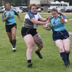 Kirsten Delozier runs the ball in front of Maggie Knight as Bambi Zhung looks on at the Kenai Dipnet Fest Rugby 10s Tournament at Kenais Millennium Square on Saturday, July 19, 2025. (Photo by Jeff Helminiak/Peninsula Clarion)