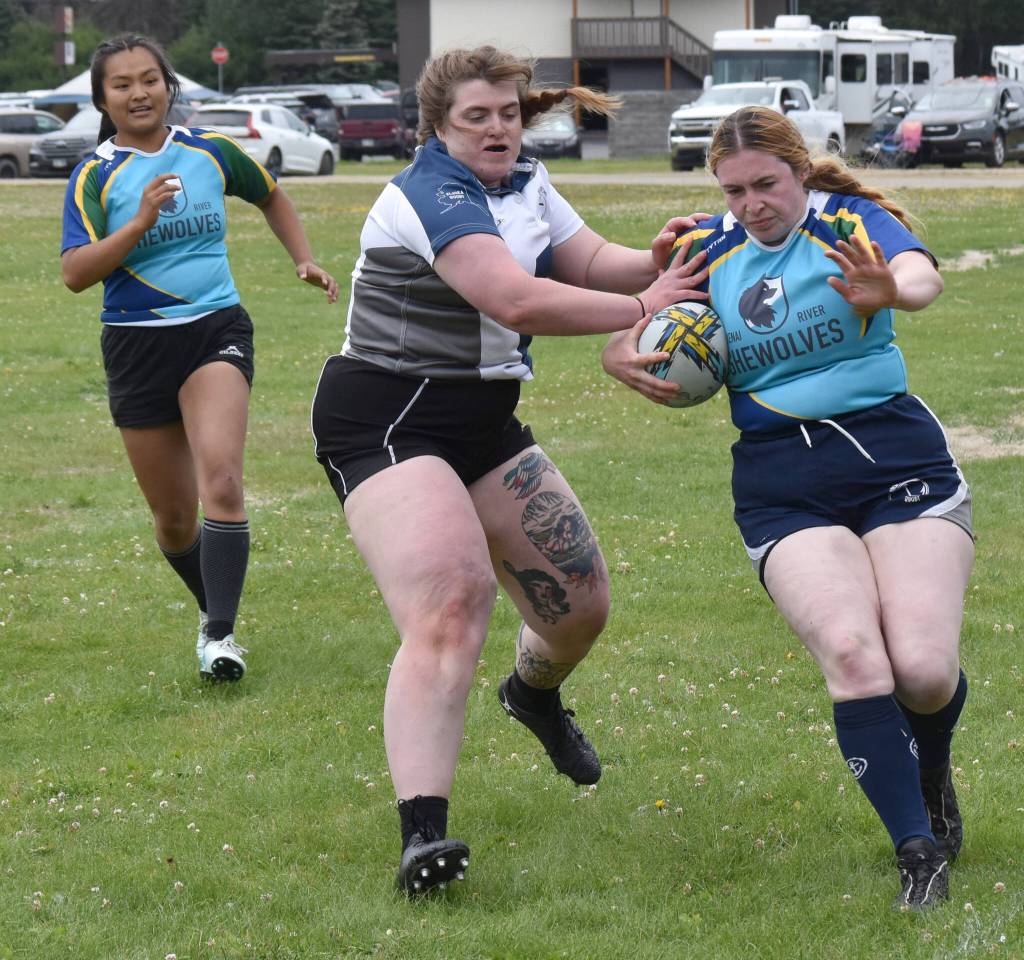 Kirsten Delozier runs the ball in front of Maggie Knight as Bambi Zhung looks on at the Kenai Dipnet Fest Rugby 10s Tournament at Kenais Millennium Square on Saturday, July 19, 2025. (Photo by Jeff Helminiak/Peninsula Clarion)