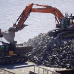Armor rock from Sand Point is offloaded from a barge in the Kenai River in Kenai, Alaska, part of ongoing construction efforts for the Kenai River Bluff Stabilization Project on Wednesday, July 23, 2025. (Jake Dye/Peninsula Clarion)