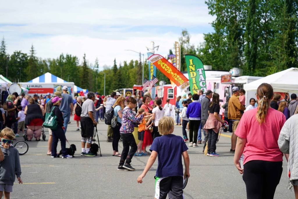 People mill between booths and food trucks at the Progress Days Block Party at Parker Park in Soldotna, Alaska, on Saturday, July 26, 2025. (Jake Dye/Peninsula Clarion)