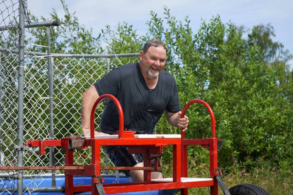 Kenai Peninsula Borough School District Superintendent Clayton Holland climbs from the dunk tank during Dunk a Dignitary at the Progress Days Block Party at Parker Park in Soldotna, Alaska, on Saturday, July 26, 2025. (Jake Dye/Peninsula Clarion)