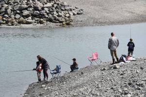 Parents show their kids how to cast their fishing lines during the youth-only coho salmon fishery on Saturday, Aug. 5, 2023 at the Nick Dudiak Fishing Lagoon on the Homer Spit in Homer, Alaska. (Delcenia Cosman/Homer News)