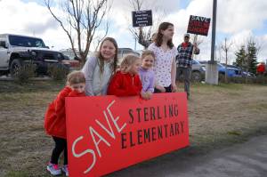 Students stand during a protest against the possible closure of Sterling Elementary School along the Sterling Highway in Soldotna, Alaska, on Saturday, May 3, 2025. (Jake Dye/Peninsula Clarion)