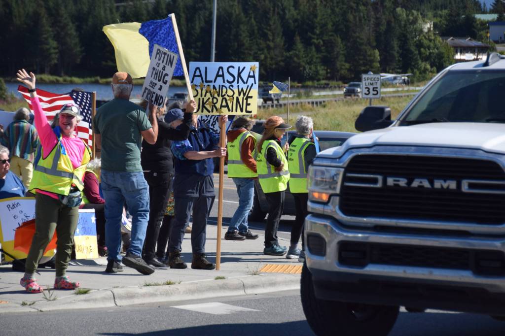 Cars drive by at the intersection of Lake Street and the Sterling Highway as protesters hold up signs expressing support for Ukraine on Friday, Aug. 15, 2025, in Homer, Alaska. (Delcenia Cosman/Homer News)