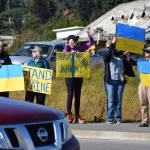 Cars pass through the intersection of Lake Street and the Sterling Highway as protesters hold up signs expressing support for Ukraine on Friday, Aug. 15, 2025, in Homer, Alaska. (Delcenia Cosman/Homer News)