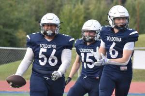 Soldotna's Koda Lepule celebrates a fumble recovery with Matthew Innes and Liam Peck on Friday, Aug. 15, 2025, at Justin Maile Field at Soldotna High School in Soldotna, Alaska. (Photo by Jeff Helminiak/Peninsula Clarion)