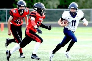 Homer's Justus Grimes shifts past a pair of Houston Hawks en route to a kickoff return for a touchdown of more than 80 yards during the second half of a 64-8 win over the Hawks on Friday, Aug. 15, 2025, at Houston High School in Houston, Alaska. (Bruce Eggleston/matsusports.net)