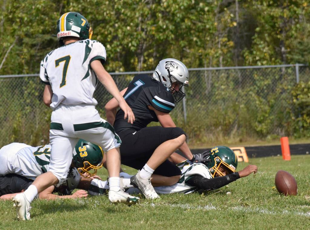 Sewards Ridge Conant and Cai Turner and Nikiskis Mason Doth scramble for a fumble Saturday, Aug. 16, 2025, at Nikiski Middle-High School in Nikiski, Alaska. Conant would pick up the ball and score. (Photo by Jeff Helminiak/Peninsula Clarion)