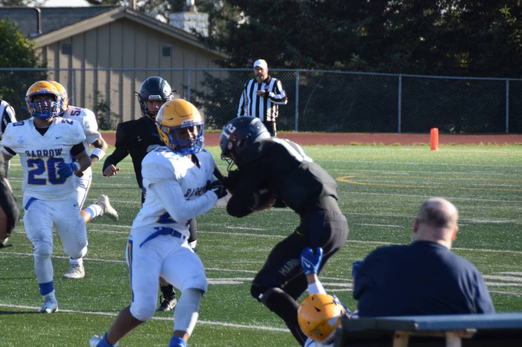 Barrow pushes Homers CJ Burns off the field on Friday, August 22. (Chloe Pleznac/Homer News)