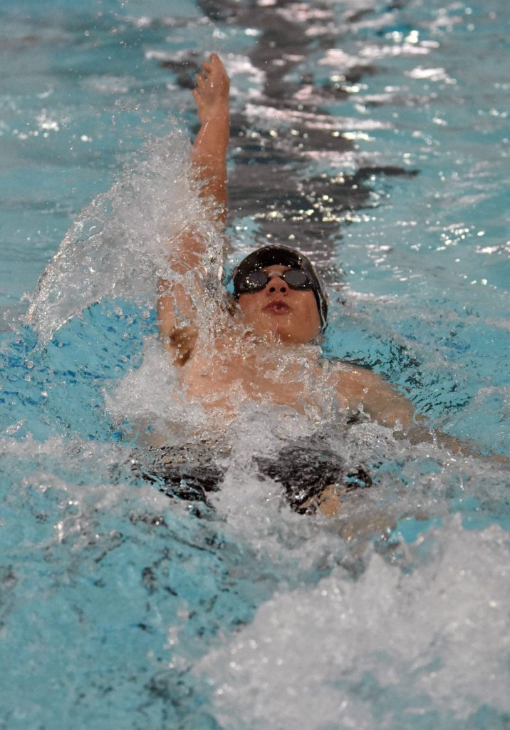 Kenai Centrals Lyman McBride competes in the 100-meter backstroke Friday, Aug. 29, 2025, at Kenai Central High School in Kenai, Alaska. (Photo by Jeff Helminiak/Peninsula Clarion)