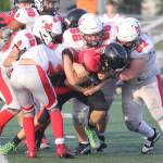 Kenai juniors Blake Morris (52) and Jackson Taliesin (66) lead a group of Kardinals as they bring down Houstons Mason Green during a 31-22 win over Houston on Friday, Sept. 5, at Houston High School in Houston, Alaska. (Photo by Jeremiah Bartz/Frontiersman)