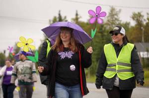 A crowd moves along the sidewalk during the Third Annual Kenai Peninsula Walk to End Alzheimers on Lawton Drive in Kenai, Alaska, on Saturday, Sept. 13, 2025. (Jake Dye/Peninsula Clarion)