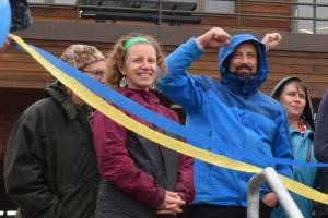 Homer Mayor Rachel Lord smiles as Homer High School counselor Paul Story and others raise a fist in jubilation for the completion of the new entrance to the school on Thursday, Sept. 11, 2025. (Chloe Pleznac/Homer News)