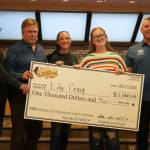 Lily Craig, second from right and youth winner of the Ninth Annual Kenai Silver Salmon Derby, stands with officials from the City of Kenai, Kenai Chamber of Commerce and Marathon Petroleum as shes awarded a novelty check for $1,000 at Kenai City Hall in Kenai, Alaska, on Wednesday, Sept. 17, 2025. (Jake Dye/Peninsula Clarion)