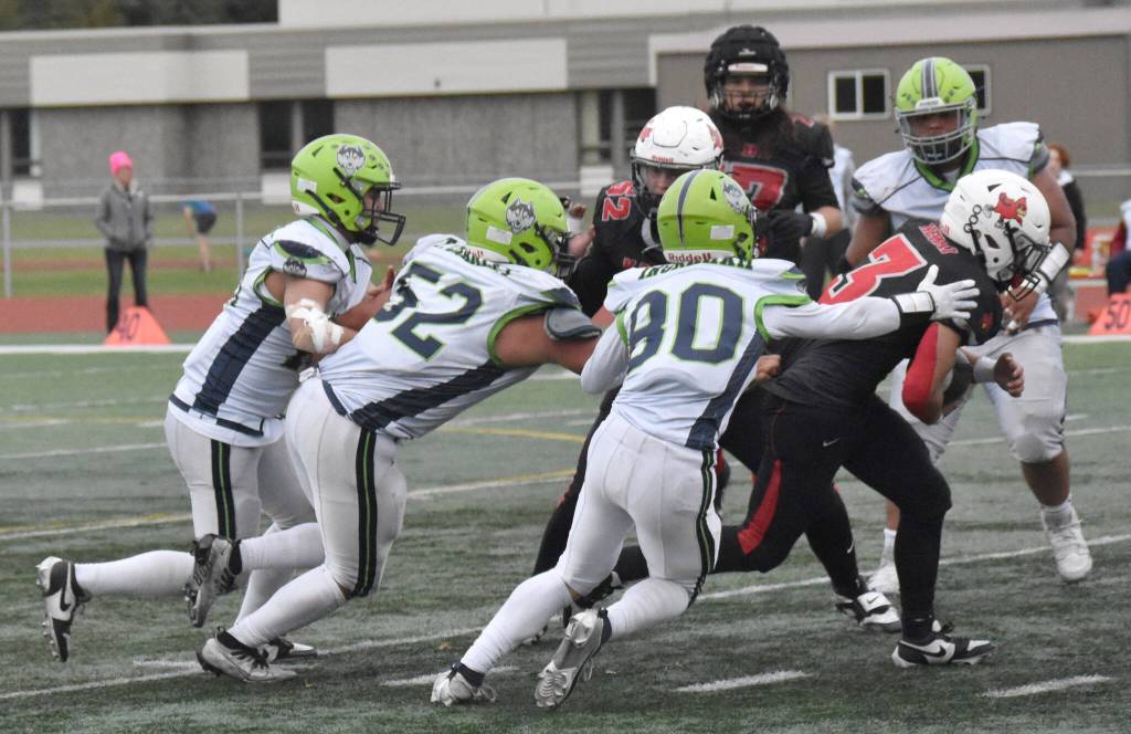 Kenai Centrals Kainoa Taylor runs while being pursued by Redingtons Triston Charley and Cayden Ingraham on Friday, Sept. 19, 2025, at Ed Hollier Field at Kenai Central High School in Kenai, Alaska. (Photo by Jeff Helminiak/Peninsula Clarion)