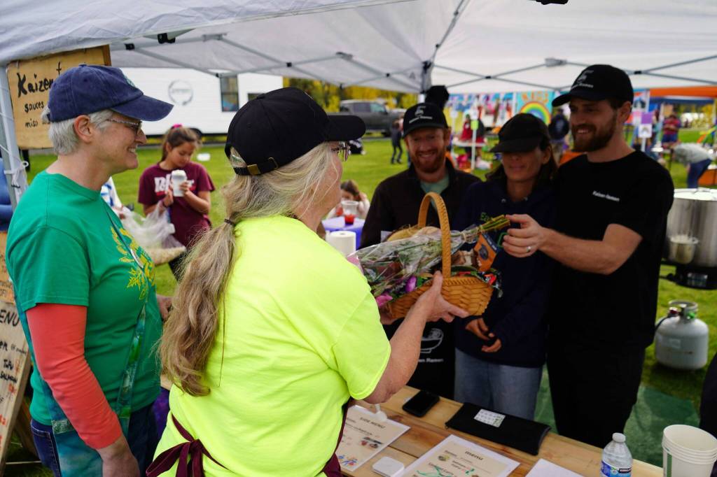 Susan Nabholz and Jeannette Pedginski recognize Gregory Eller, Saori Habuta and James Eller of Kaizen Ramen as the Most Local Food vendor during the Harvest Moon Local Food Festival at Soldotna Creek Park in Soldotna, Alaska, on Saturday, Sept. 20, 2025. (Jake Dye/Peninsula Clarion)