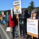 Protesters hold signs on the sidewalk along Sterling Highway during a No Kings demonstration on Saturday, Oct. 18, 2025, in Homer, Alaska. (Delcenia Cosman/Homer News)