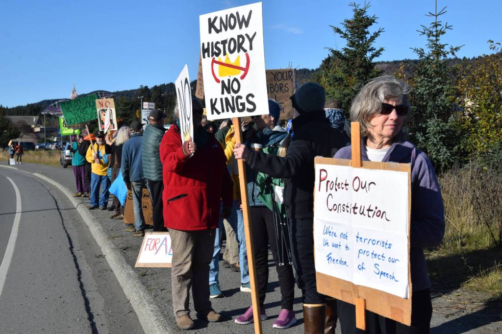 Protesters hold signs on the sidewalk along Sterling Highway during a No Kings demonstration on Saturday, Oct. 18, 2025, in Homer, Alaska. (Delcenia Cosman/Homer News)