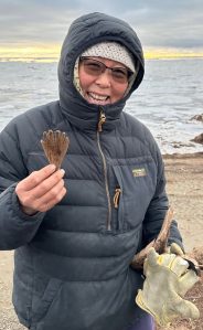 Quinhagak resident Sarah Brown holds a mask attachment she found on the beach on Oct. 24, 2025. This item might represent a hand or fin of an animal or spirit being. Photo courtesy Alice Bailey