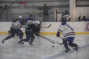 Homer and Soldotna hockey players battle for the puck during the Carlin Cup home varsity game on Saturday, Dec. 13, 2025, at the Kevin Bell Arena in Homer, Alaska. (Delcenia Cosman/Homer News)