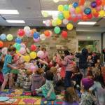 Balloons fall on dozens of children armed with confetti poppers during the Ninth Annual Noon-Years Eve Party at the Soldotna Public Library in Soldotna, Alaska, on New Years Eve, Tuesday, Dec. 31, 2024. (Jake Dye/Peninsula Clarion)