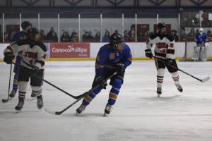 Flanked by JDHS freshmen Manu Adams, left, and Paxton Willoughby, right, Homer junior Berend Pearson looks for a pass from a teammate. The Crimson Bears and the Mariners faced off at the Treadwell Arena in Juneau following the Bears senior night ceremony on Friday, Jan. 23.<ins>, 2026</ins>