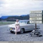This 1950s photo from the University of Alaska Anchorages archives and special collections, shows a traveler and her car posed between a mileage sign and Mud Lake.