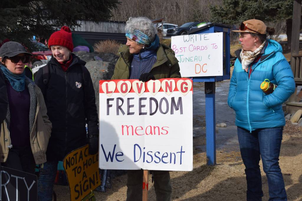 A protester carries a sign that reads, Loving Freedom means We Dissent, during the No Kings protest on Saturday, March 28, 2026, in Homer, Alaska. (Delcenia Cosman/Homer News)