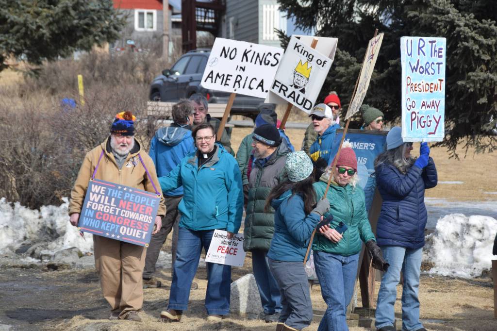 Protesters carry signs during the No Kings protest on Saturday, March 28, 2026, in Homer, Alaska. (Delcenia Cosman/Homer News)