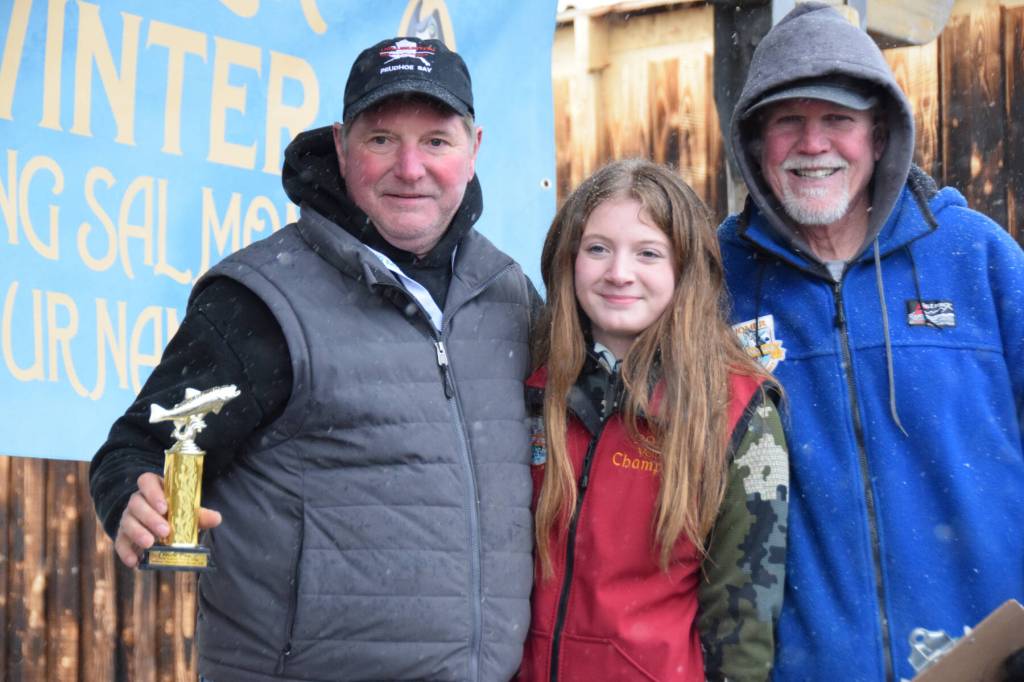 Delcenia Cosman / Homer News
Aaron Challans from Soldotna poses with his daughter and 2025 Top Youth Angler winner Madelyn Challans (center) and Homer Chamber of Commerce executive director Brad Anderson (right) after winning 10th place during the 32nd annual Homer Winter King Tournament on Saturday, April 4.