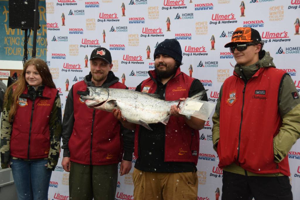 Michael Ardenia (center right), winner of the 32nd annual winter king tournament, holds up his winning fish alongside past tournament and youth champions during the 32nd annual Homer Winter King Tournament on Saturday, April 4, 2026, in Homer, Alaska. (Delcenia Cosman/Homer News)