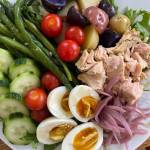 Tressa Dale/Peninsula Clarion There are endless variations of this dish, but standard ingredients include green beans, boiled eggs, potatoes, olives, tomatoes, and high-quality canned fish like tuna or sardines, all on a bed of greens and dressed with a sauce of lemon and oil with herbs, capers, mustard, and anchovies.