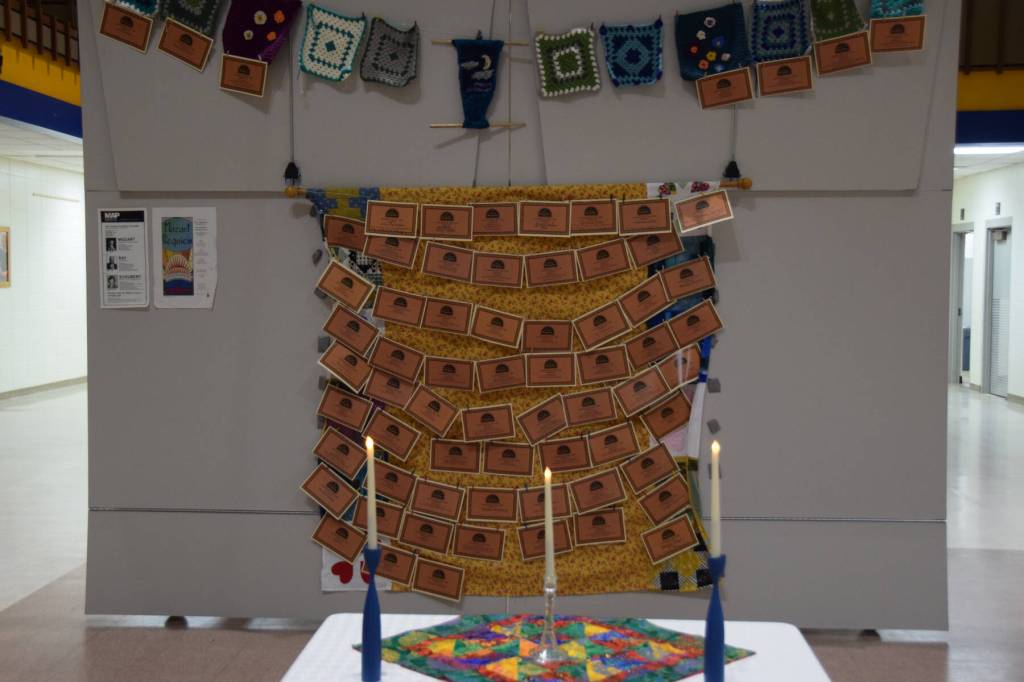 A memory wall with memorial dedication certificates made in partnership with Pier One Theatre is displayed in the Homer High School commons during the performance of the Mozart "Requiem" on Friday, May 1, 2026, in Homer, Alaska. (Delcenia Cosman/Homer News)