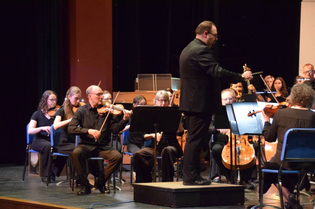 Homer High School choir director Kyle Schneider conducts the Mozart "Requiem" on the Homer High School Mariner Theatre stage on Friday, May 1, 2026, in Homer, Alaska. (Delcenia Cosman)