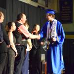 Homer High School Class of 2026 valedictorian Lukas Renner (center) shakes hands with Kenai Peninsula Borough School District representatives as he receives his diploma in a commencement ceremony on Monday, May 18<ins>,</ins> <ins>2026</ins>, in the Homer High School Alice Witte Gymnasium<ins> in Homer, Alaska</ins>. (Delcenia Cosman/Homer News)
