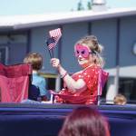 A masked woman waves a small American flag during the 2025 Fourth of July parade on South Willow Street in Kenai. (Photo courtesy Sarah Every)