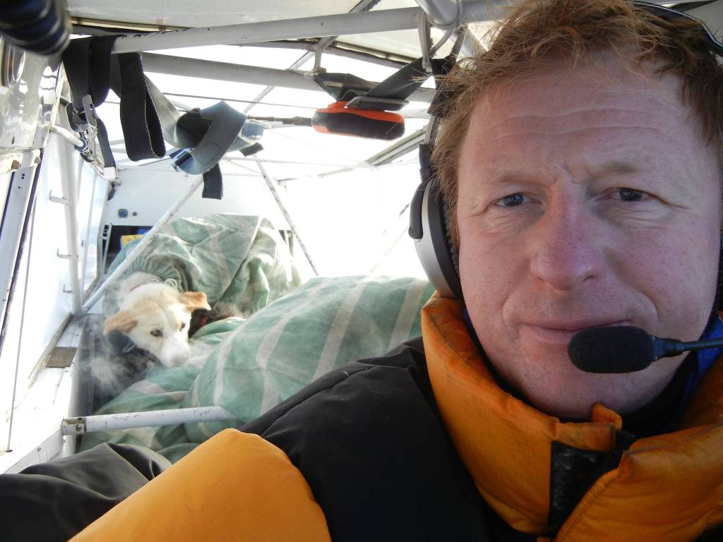 Martin Stuefer pauses before taking off from Eagle, Alaska, during the 2011 Yukon Quest. Stacked behind him are seven sled dogs in burlap sacks. (Photo by Martin Stuefer)